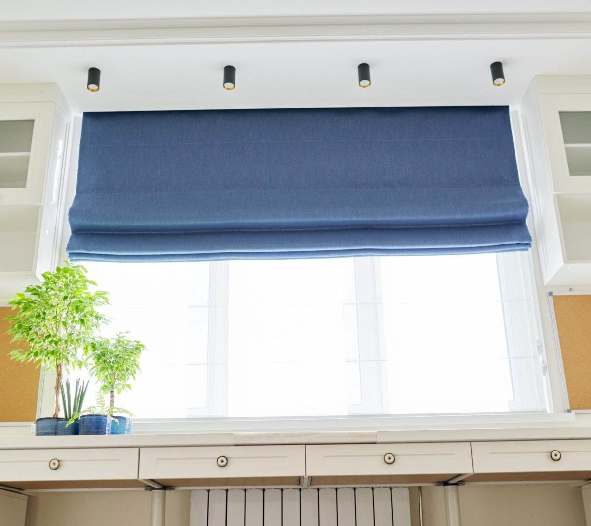 Roman blind in the interior detail close-up. Curtain blue blackout fabric, sheers white linen, fashionable modern window decoration design at home