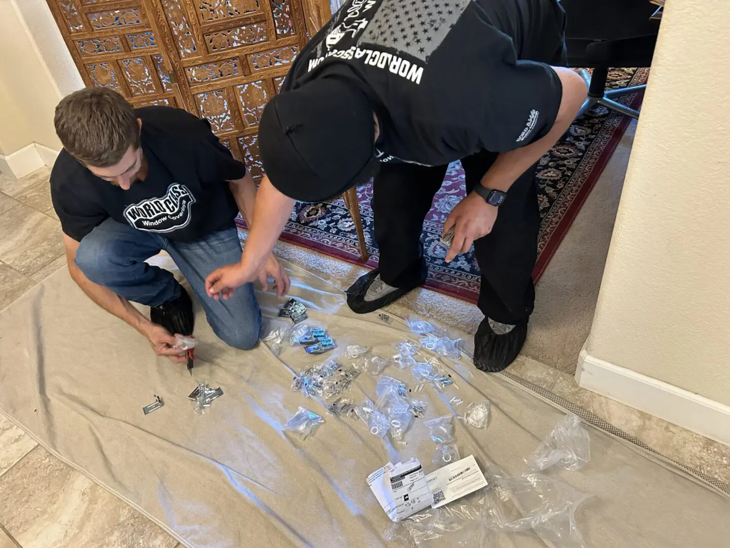 Two men assembling window coverings.