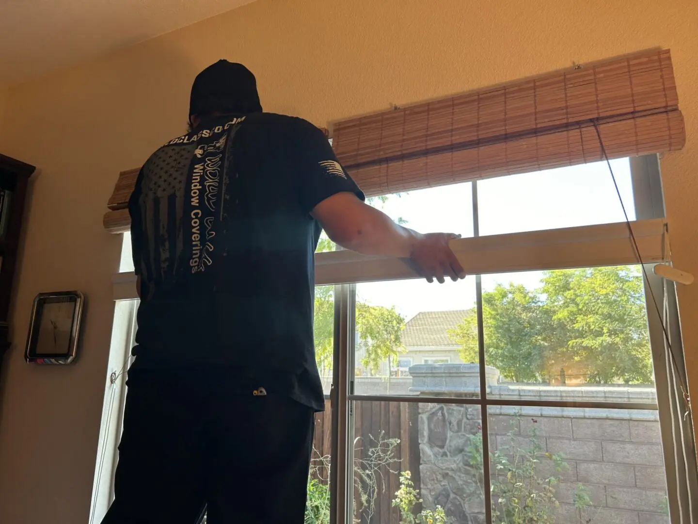 Man installing window blinds with logo.