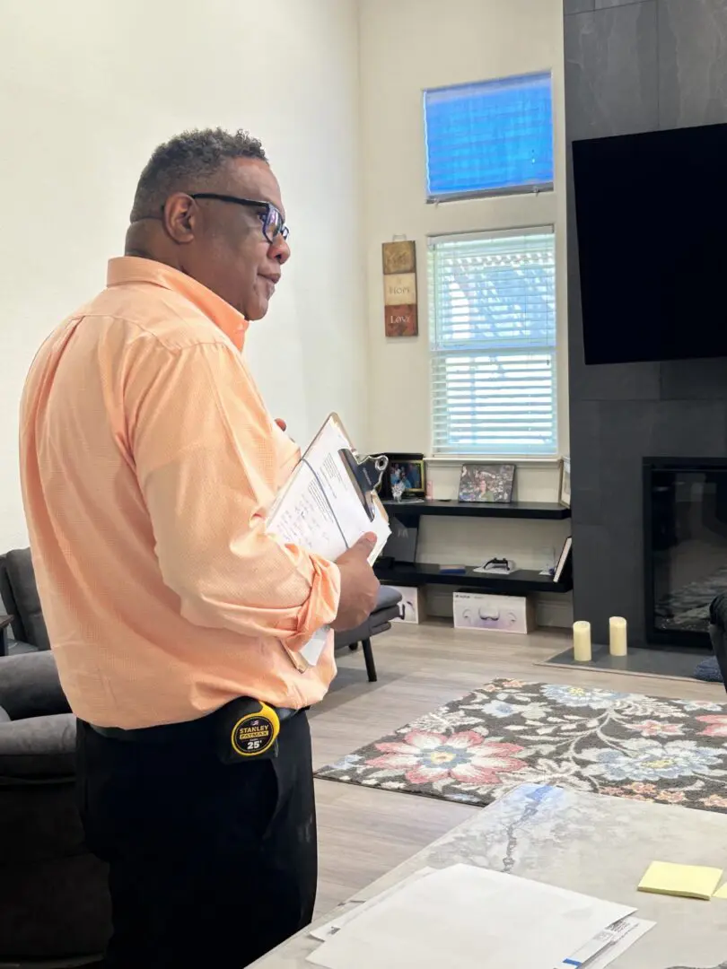 Man holding clipboard in living room.