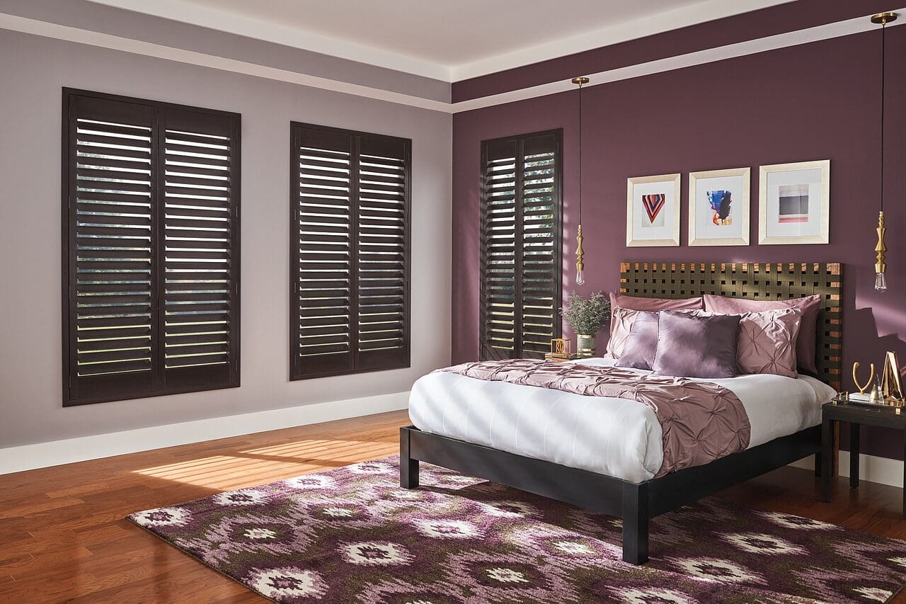 Bedroom with wooden shutters and rug.